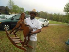Darron Moore carries a rocking horse to a car today during a yard sale at Dynamite’s house.