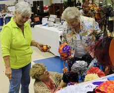 June Hawkins, left, Linda Brown, center, and Patsy Quarles are giving homemade items finishing touches for their display.