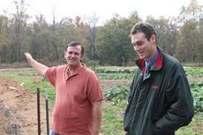 Chad Manaton, left, and Jean-Pierre Wersinger show where a greenhouse is being built on property where they began producing local produce for subscription paying customers.