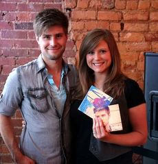 Kirstie Wortkoetter shows the two covers of Dylan Arms' CDs during his pre-release party for 