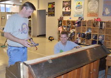 Jamie Dewberry and Andy Wettlin work on refurbishing a donated piano that will be used in Mary Poppins.
 