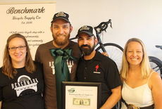 Benjamin Griswold, Benjamin Schwoe and Tiana Cain (right) are the owners of the Benchmark Bicycle Supply Co. Griswold's wife, left, and the business partners had a euphoric ribbon cutting and grand opening on Friday.