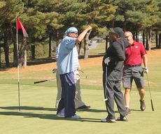 Greer Chief Municipal Judge Henry J. Mims, black shirt, sank a birdie putt to make his team happy on this hole in the captain's choice format.
 