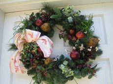 The unique wreaths, such as this one, illustrate's Susan's skills as a Master Gardener. The designs are creative using flowers, fruits and greenery.