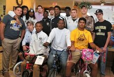 Greer High School football players annually contribute toys and their time at the Clock restaurant, where the toys are collected.