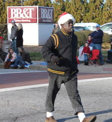 Gee is front and center at the intersection of Main and Poinsett streets as he signals the approaching Greer High School contingent in the annual Greer Christmas Parade.
 
