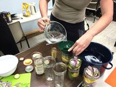 Liz Wilfong adds vinegar solution before sealing containers.
 