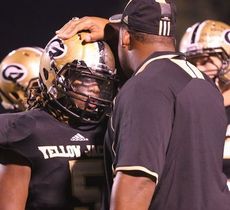 Marquis Lyles, defensive end, gets a job well done tap on the helmet from defensive line coach Rashaad Jackson.
