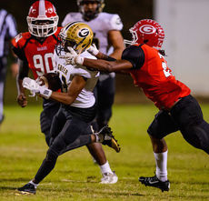 A Greenville player reaches for a high tackle to bring down a Greer runner.
 