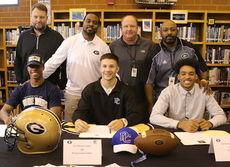 Tony Pride, Jr., left, joined his teammates, Mario Cusano, center, and Dorian Lindsey at a signing ceremony at Greer High School. Coaches from the left are, Head Coach Will Young, Mazzie Drummond, Travis Perry and Erie Williams.
 
 