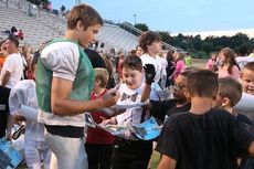 Mario Casano, a sophomore transfer quarterback from Florida, draws a crowd of youth football players seeking his autograph after his performance against Gaffney Thursday.