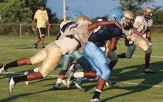 A Greer player pulls down a J.L. Mann runner from behind while others are in pursuit.