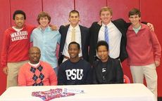 A group photo op marks the signing ceremony for Austin Riggins.
 