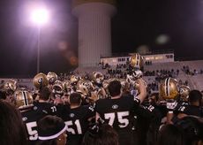 Greer players raise their helmets during pre-game warmups