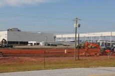 BMW Manufacturing Co. in Greer is expanding the paint shop (background) for the coming X4 model. A conveyor system (above, right) is in place with another to be built beside it to transport vehicles under production to work stations.