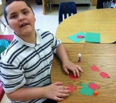 Washington Center student Zachary Satterfield learns more about apples in Billy Chapman’s class as he makes a craft of an apple tree.