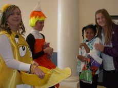 Washington Center student Daria Jenkins escorted by Christ Church Episcopal School volunteer, Lily Posta, delights in receiving treats from friends from Greenville Pediatric Dentistry during the school’s annual Boo in the School activity.