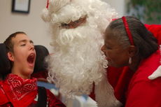 Washington Center student Duke Moore and Para-Educator Rhonda Dreher celebrate the joy of the season with Santa.