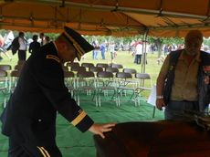A military officer kneels in prayer at the casket of Pfc. Adam Corey Ross at the end of todays funeral with full military honors.