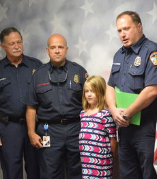 Emma Davis was honored by the Greer Fire Department on the morning show at Chandler Creek Elementary Tuesday. Left to right are Deputy Fire Marshal Carl Howell, Fire Marshall Scott Keeley, Emma, and Fire Chief Dorian Flowers.
 