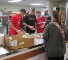 North Greenville University basketball players help serve barbecue during Big Thursday's lunch.
 