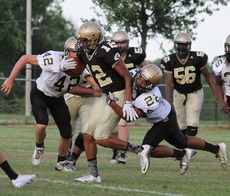 Dorian Lindsey (12) is brought down by Quay Thackston (22) as Brodie Wright (42) closes in.
 
 