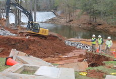 Blue Ridge Rural Water Company workers try to get a retaining wall up, anticipating a heavy rain event Wednesday, and getting dirt back into a huge hole that was the result of a huge water main break at the Lake Cunningham water treatment facility.
 