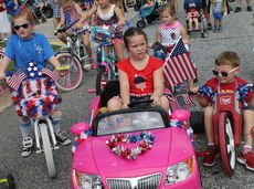 Children, all decked out in red, white and blue, line up at the start of the parade. 