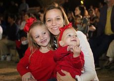 Lindsey Lawter and her daughters watch Santa read a story at the City Park amphitheater.