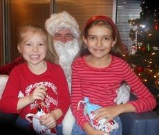 Madison, left, and Morgan Tucker have Santa all to themselves as they pose for a photo, at the request of their grandmother, at Greer's Commisison of Public Works. Madison is featured on the home page gallery talking to Santa.