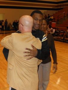 Jaz Henderson shares a hug with Greer coach Jeff Neely as senior basketball players and cheerleaders were honored between the boys and girls games.