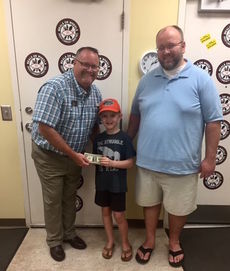 Hudson Hopper, 9, makes a cash donation to Stephen Smith, Greer Community Ministries Executive Director. Mark Hopper is on the right.
 
 