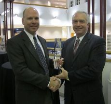 Wade Herrin, left, of GE receives the Unsung Heroes corporate award from Dr. Keith Miller of Greenville Tech.