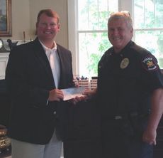 Lt. Jim Holcombe of the Greer Police Department accepts a $2,000 donation from Allen Clardy of the Clardy Law Firm. The law firm is the corporate sponsor.