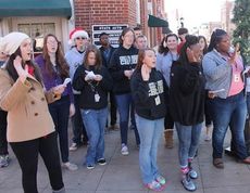 Carolers from the Greer High School Honor Choir wave to passersby Thursday in downtown Greer.
 
