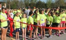 The iMove 5k Walk/Run had a special starter. Amanda Bishop, Miss Wade Hampton, far left, held the ribbon as runners gathered for the start.