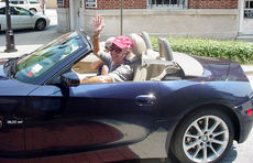 A Roadster enthusiast waves to passers-by as they cruise Greer.