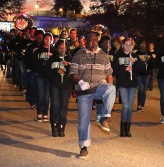 Gee leads his own parade, in front of the Greer High School Marching Band, Friday night.
 
