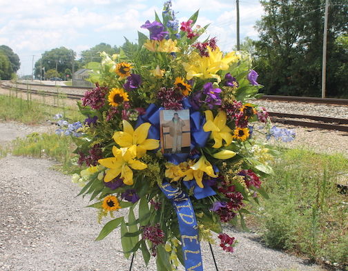 A standing spray of flowers is set alone beside the Norfolk Southern Railroad tracks at the end of Depot Street to mark where David Allen 
