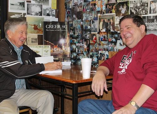 Buzzy Stewart and Leland Burch share a hearty laugh Monday during a book signing at Rosie's. Stewart bought four books.