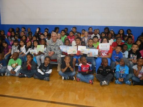 Sgt. Martin Bowen enjoys being surrounded by the children of the Creative Advancement After School Program at Victor Gym. They produced 708 Thanksgiving cards with verses for all the soldiers processed through Greer and now serving in Kosovo.