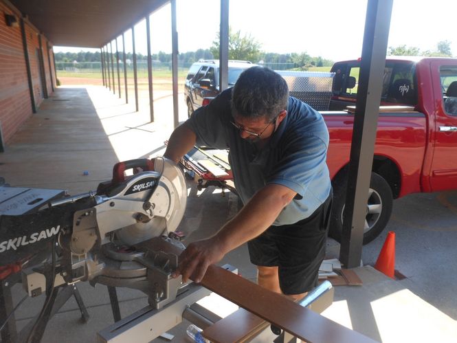 Tom Center, who donated the wood panels and equipment, cuts the wood into exact sizes so it fits like a puzzle.