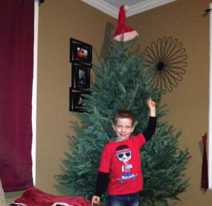 Brayden Michael Winslow points to a Christmas tree that needs some decorating.
 