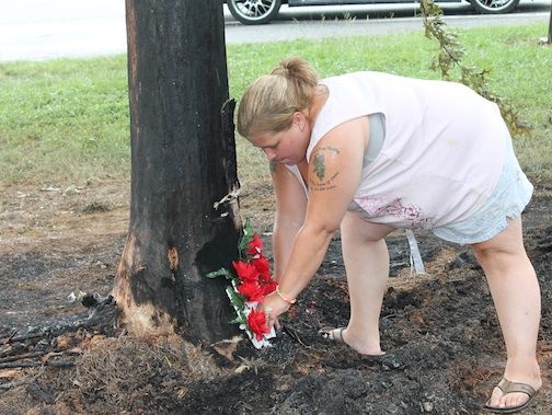 A remembrance for two people killed and one severly burned is placed at the the base of the tree where the crash occurred on Hammett Bridge Road Wednesday morning.
 