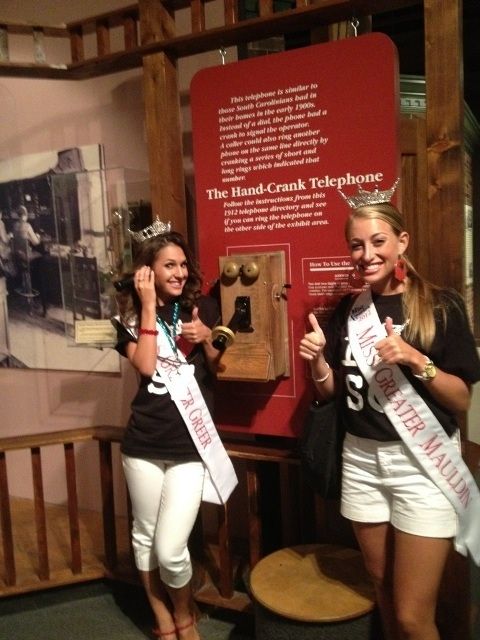 Lauren Cabaniss, 2012 Miss Greater Greer, left, tries her turn at the hand-cranked telephone. 