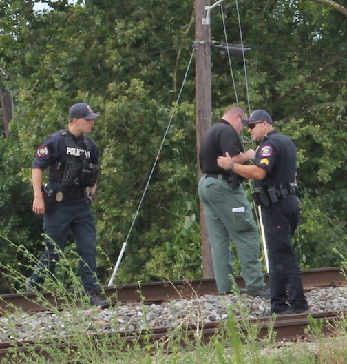 Officials study the path of an oncoming train that collided with David Allen Deane.
 
 