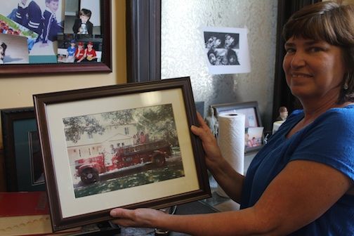 Julie Linderman shows a picture of a 1941 Chevy Southern pumper truck purchased new by the city.  Allen Cullun, grandson of B.A. Bennett, who later bought the truck, gave it back to the city to be refurbished for the fire department’s 100th anniversary in 2014.