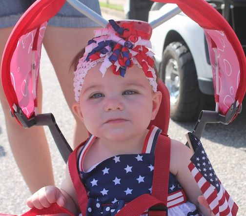 The July 4 parade includes children adorned with red, while and blue.
 