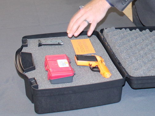 The gun, magazine, bullets and card indicating 