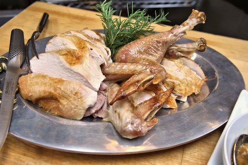 The platter is dressed with white and dark meat set aside. The drumsticks are part of the decor, until a guest claims them.